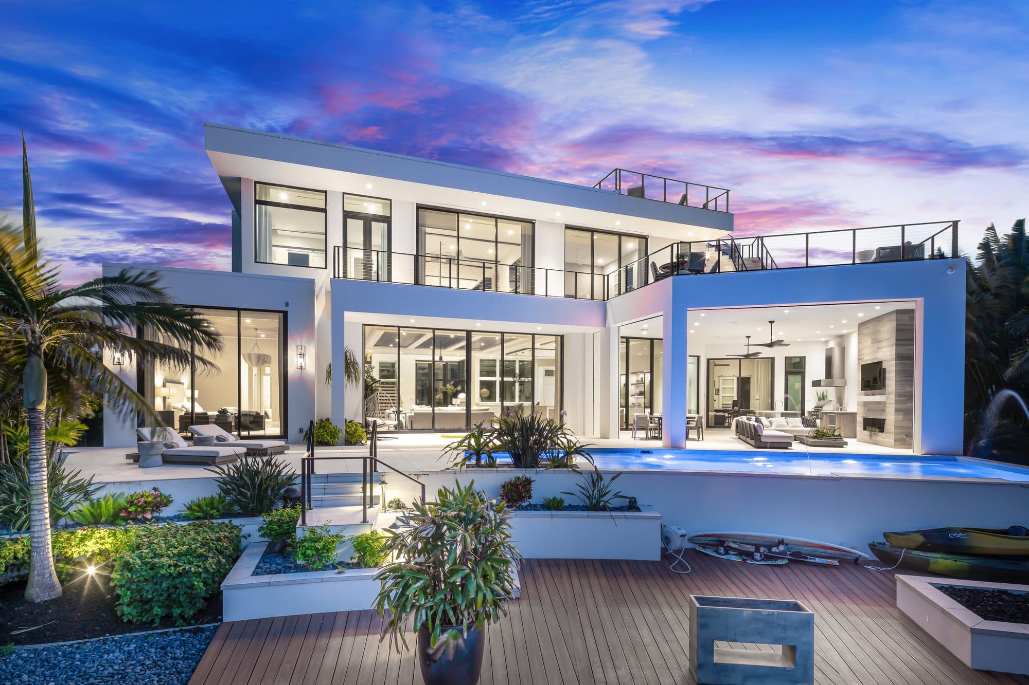 Modern waterfront home glowing at dusk